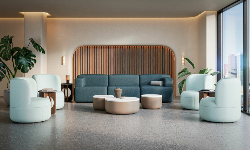 A modern, bright office lounge featuring light blue Dotti chairs and a sofa with a city view.