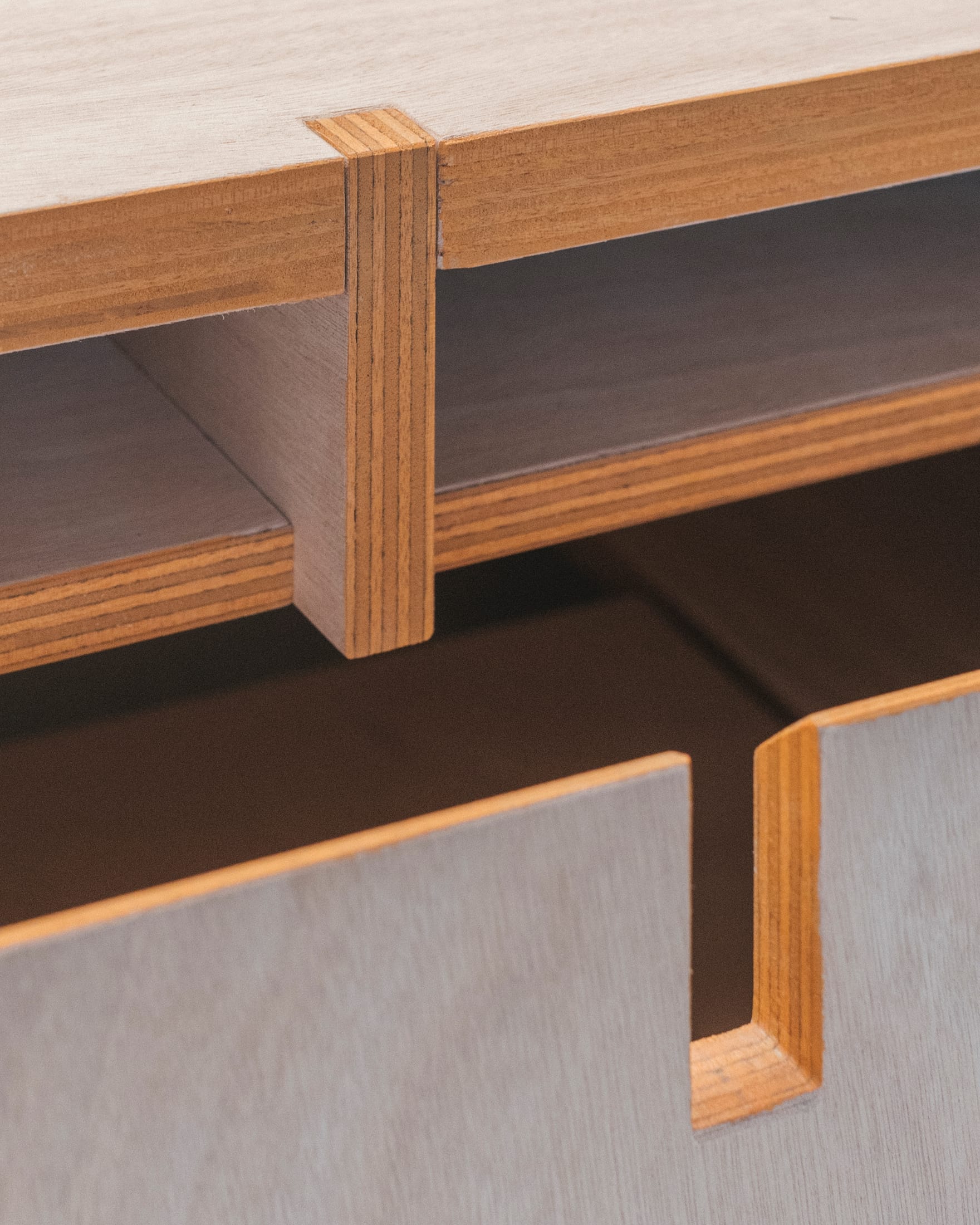 Finished ceramic pieces displayed on a minimalist shelf within the workshop.