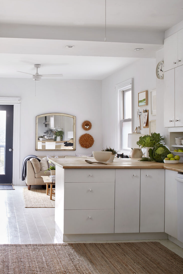 A minimalist kitchen with white-painted pine floors and birch countertops.