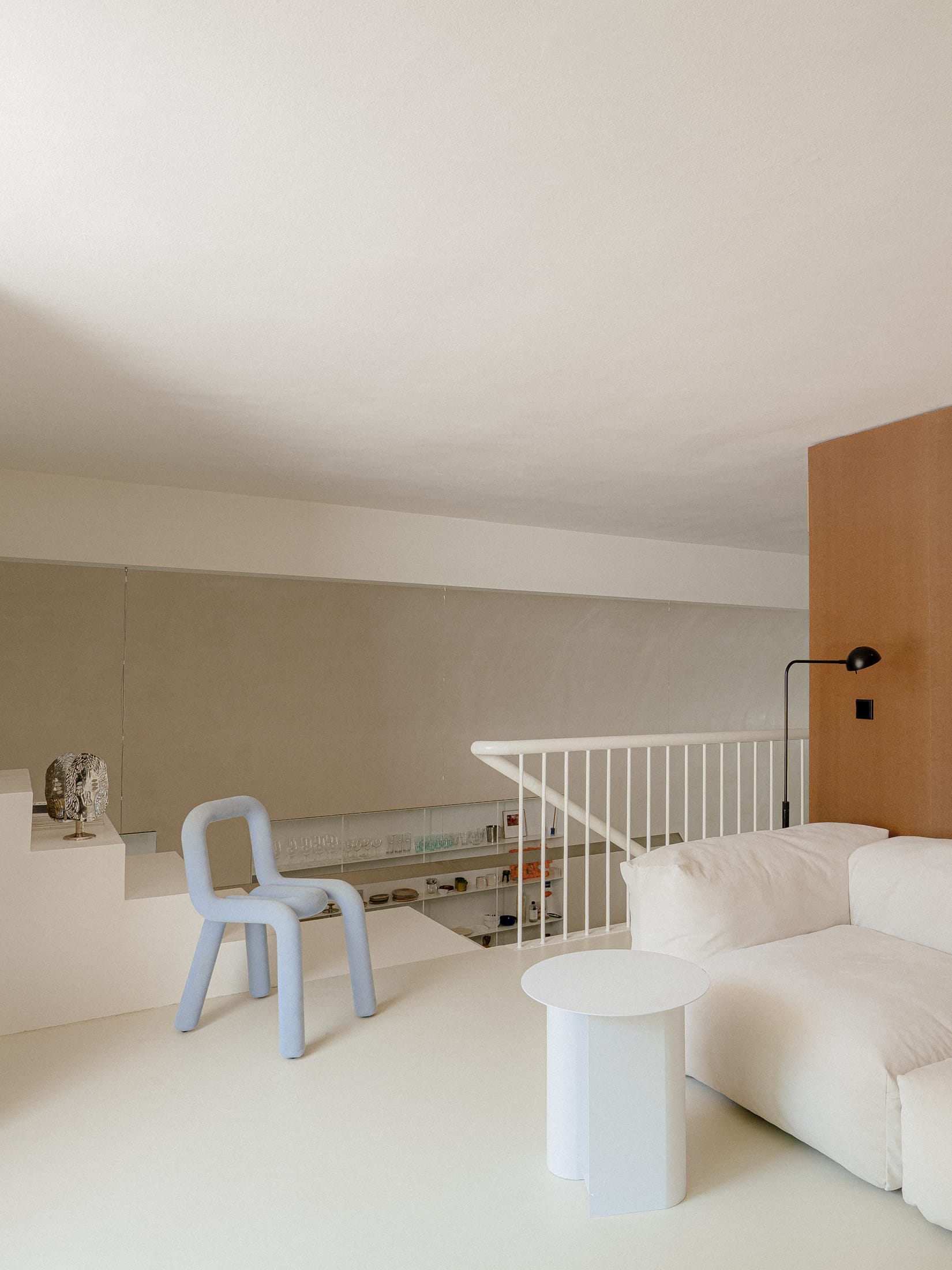 Internal perspective showing the narrow circulation path and the connection between the ground floor and mezzanine.