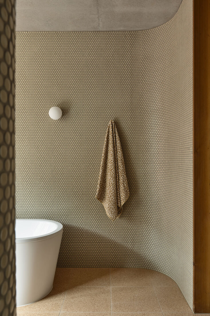A coastal home bathroom with grouted tile floors and an open bath layout.