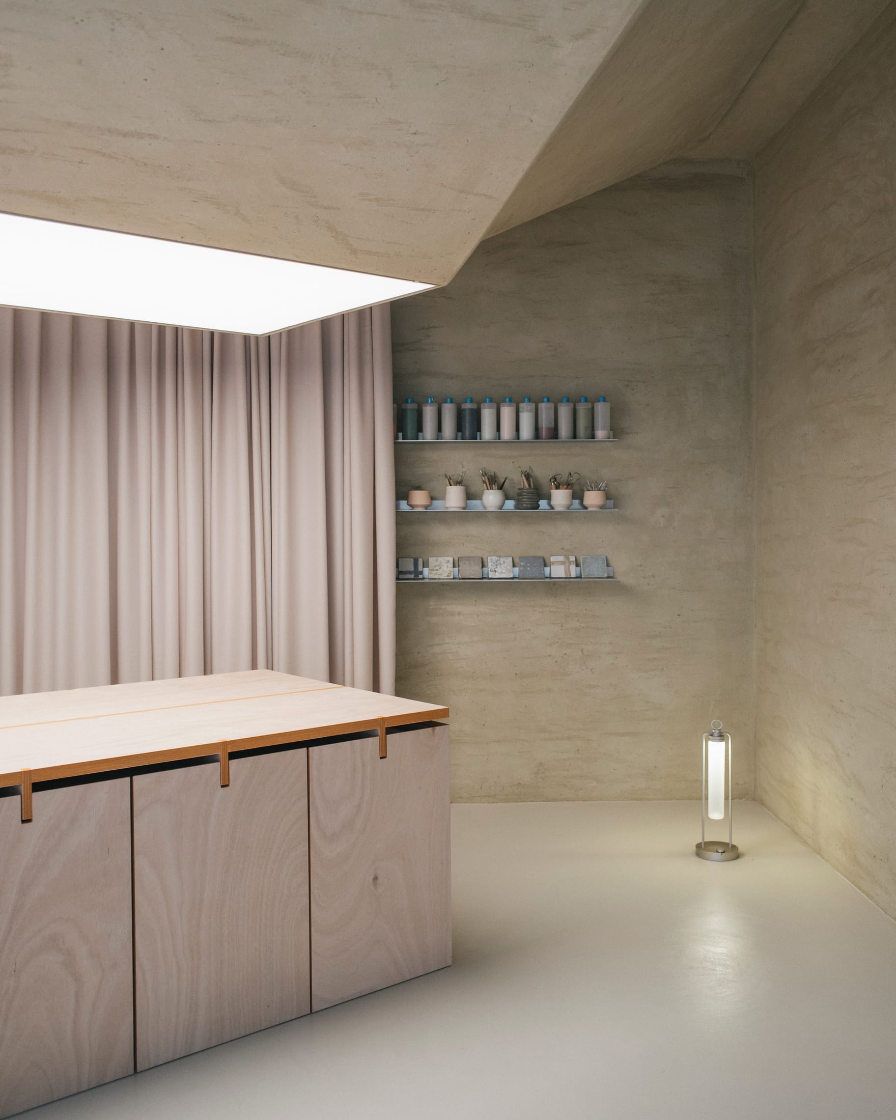 Wide shot of the Mosca Bianca ceramic studio in Padova showing the minimalist interior and timber furniture.
