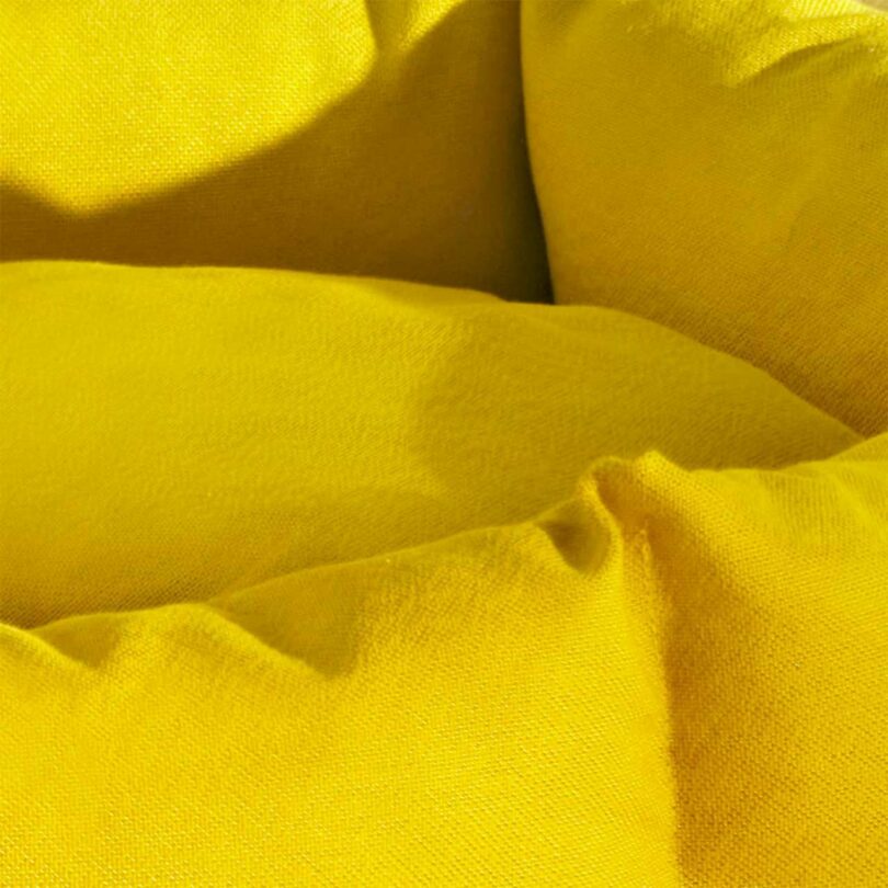 A close-up detail shot of the yellow Kvadrat fabric upholstery on a dog bed.