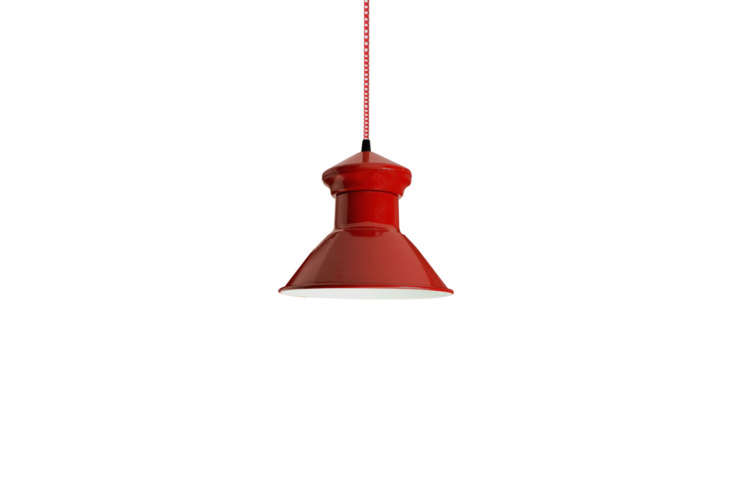 A vintage red barn pendant light hanging in a dining area.