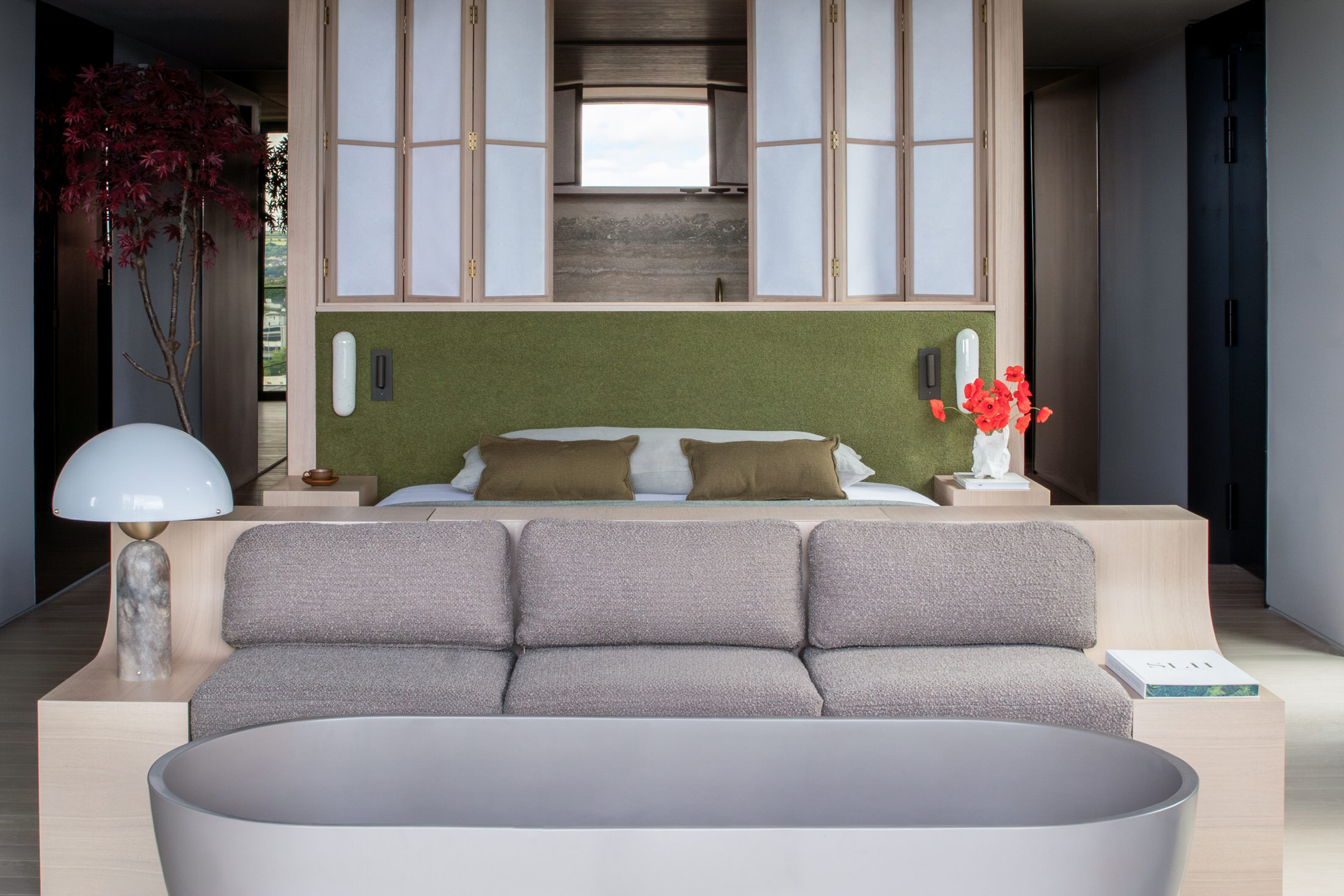Interior of a luxury suite featuring warm timber walls and a large window framing woodland views.