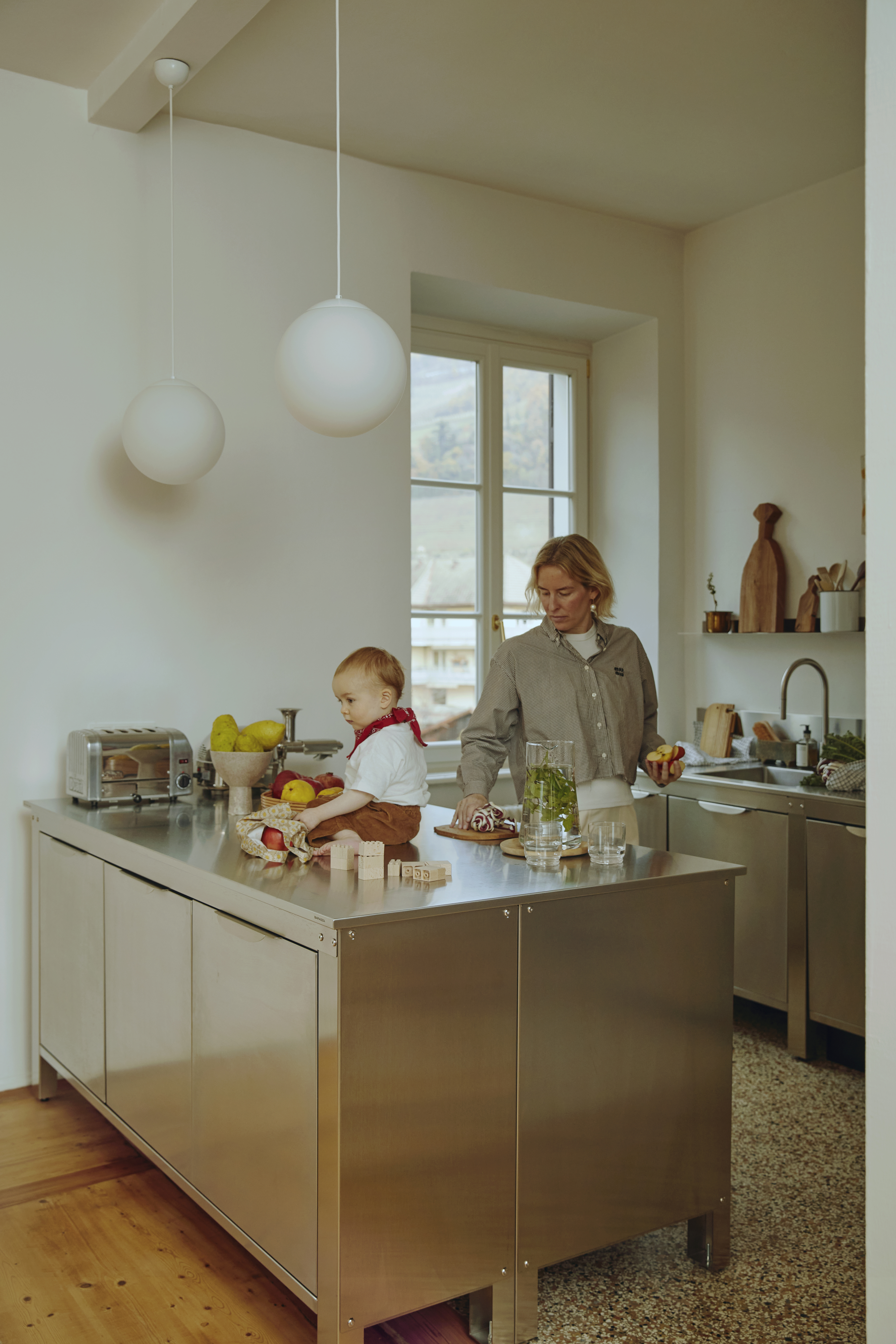 Modern stainless steel galley kitchen configuration featuring modular wall and island units.