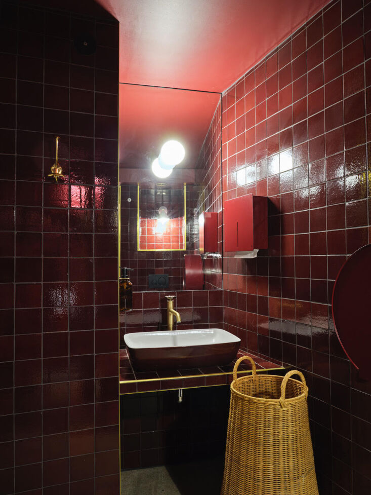 Bathroom featuring glossy claret red tiles and a Bordeaux-colored sink.