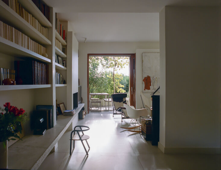 A Le Corbusier cowhide lounge chair next to a built-in concrete bench that extends toward the garden.
