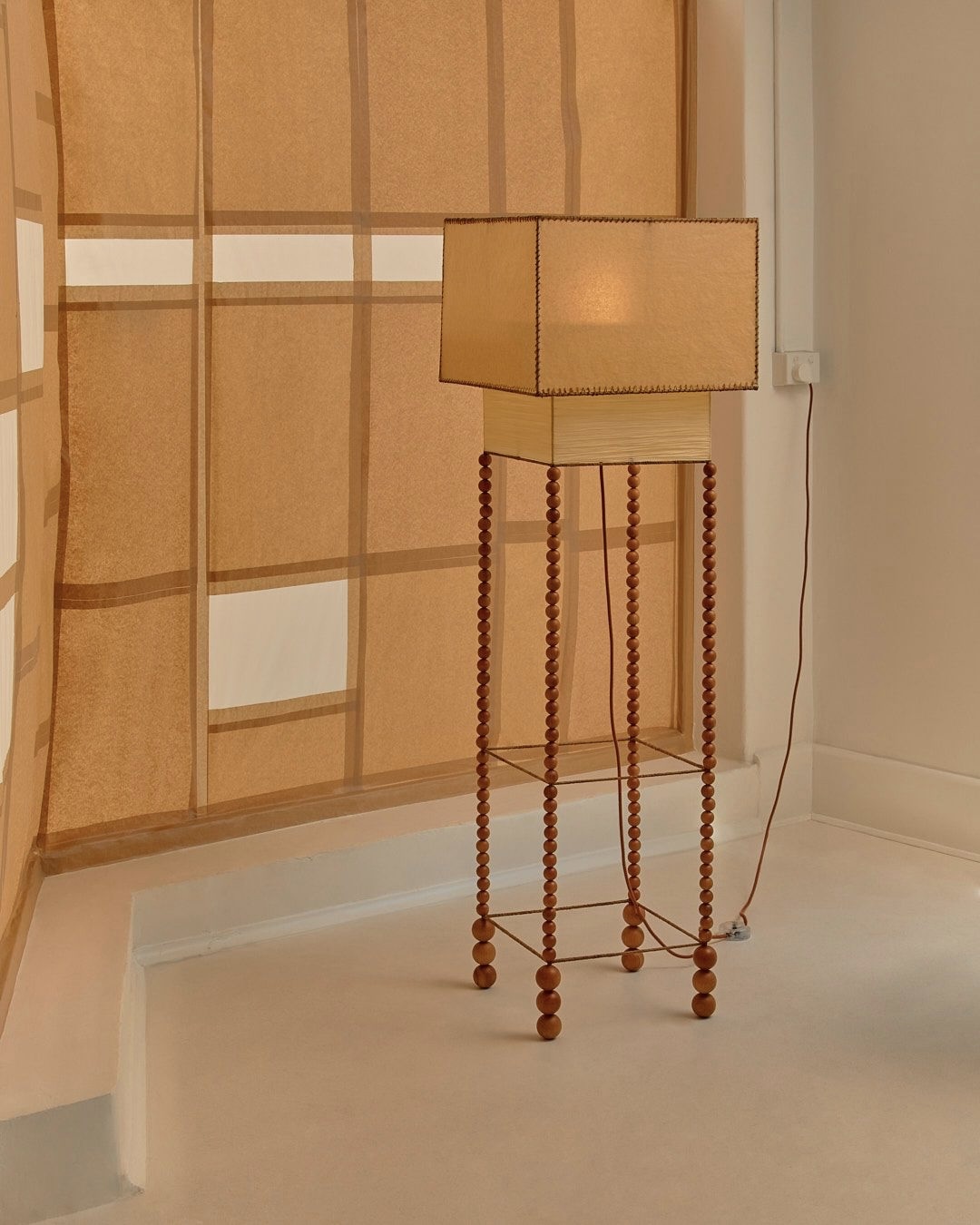 The Feels Like Home Floor Lamp with a waxed parchment shade and oiled beechwood bead base.