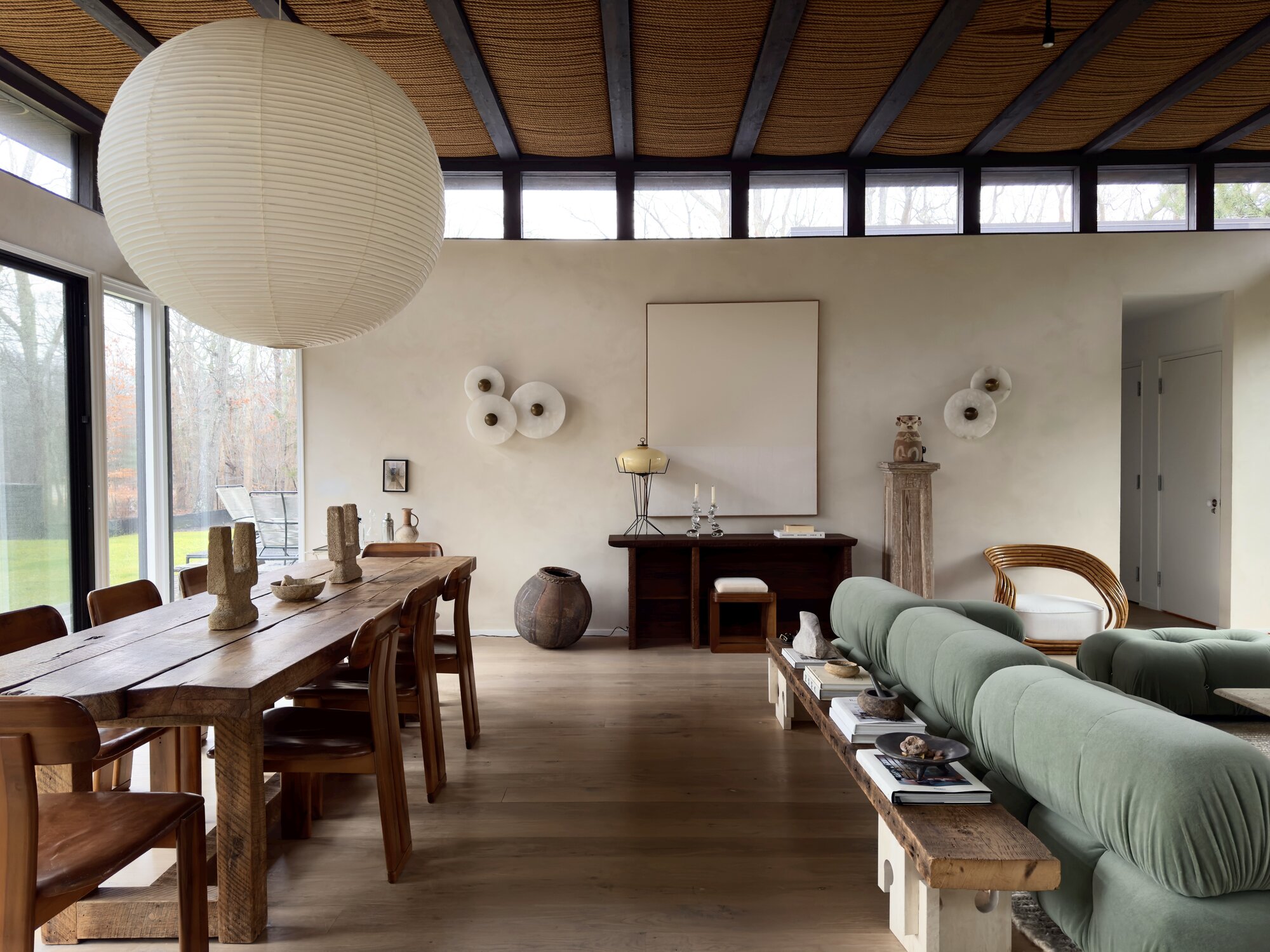 A stylish dining room showcasing a modern light fixture with smoked glass and gold accents.