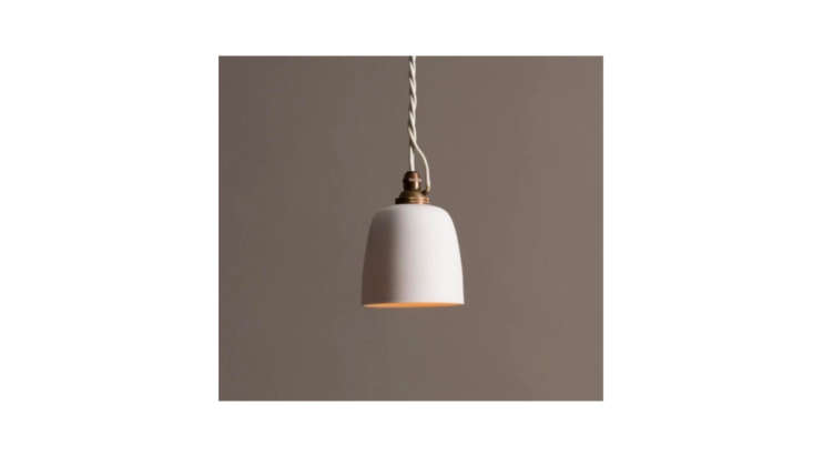 Small porcelain beaker pendant lights hanging on either side of a bed.