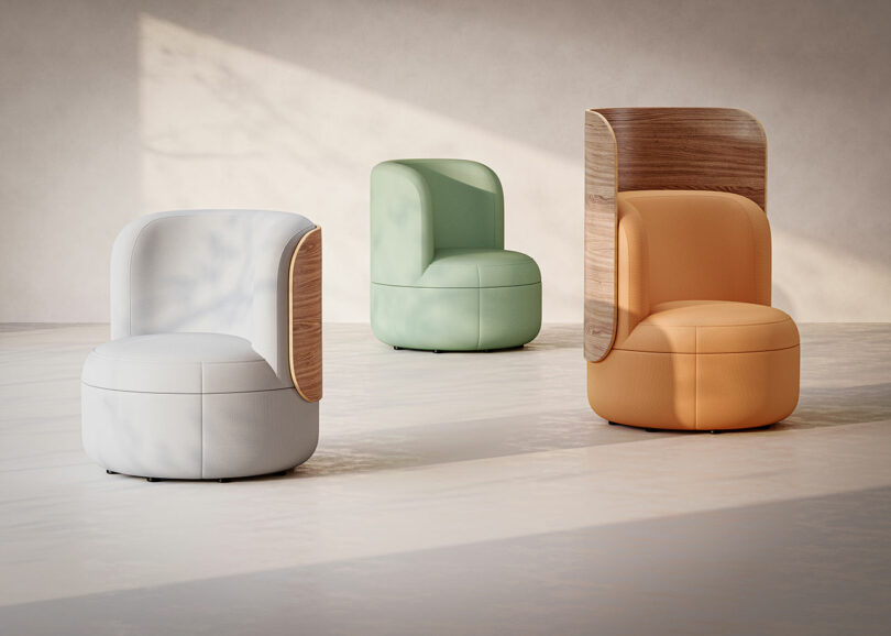 Three Dotti armchairs in white, mint green, and orange with wooden back accents.