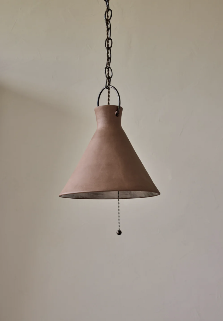 A dark brown Mud ceramic pendant light with visible brass hardware.