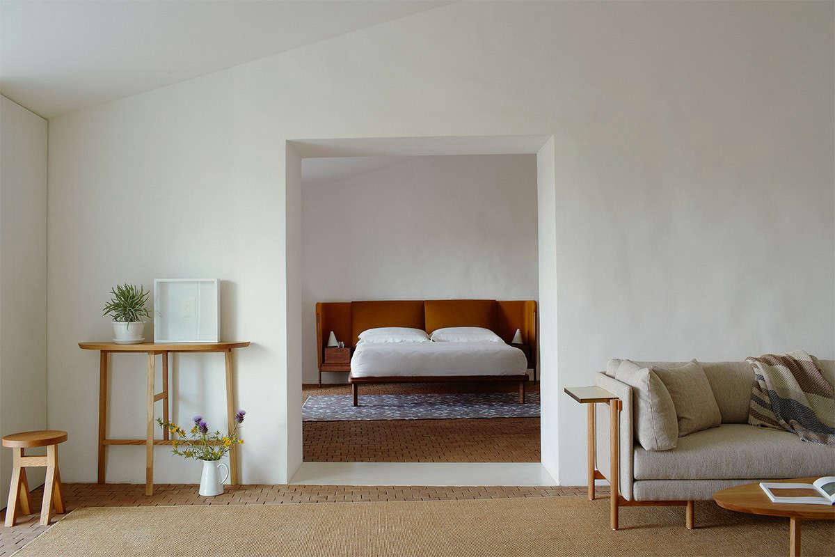 The living room at Casa No Tempo with integrated Neri & Hu furniture and minimalist white walls.
