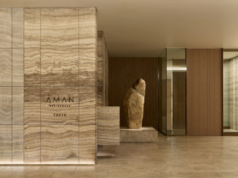 Lobby area featuring a large, textured stone sculpture as a centerpiece amidst wood and stone architecture.
