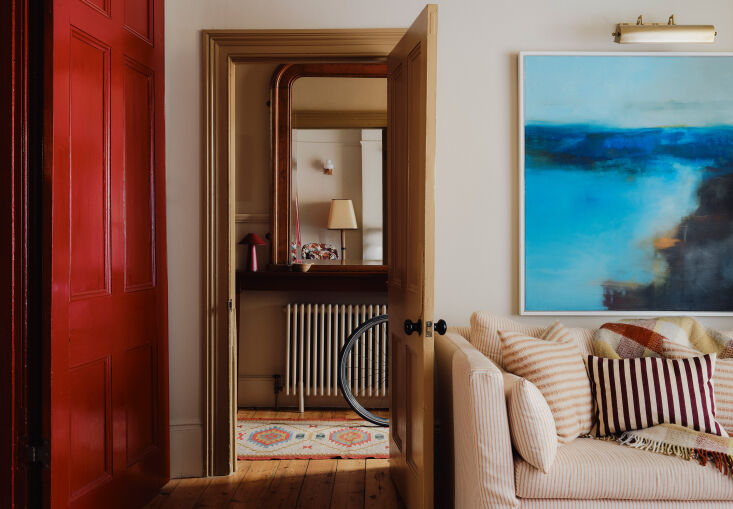 A view from a living room into an entry hall showing a sophisticated and calm color palette across different rooms.