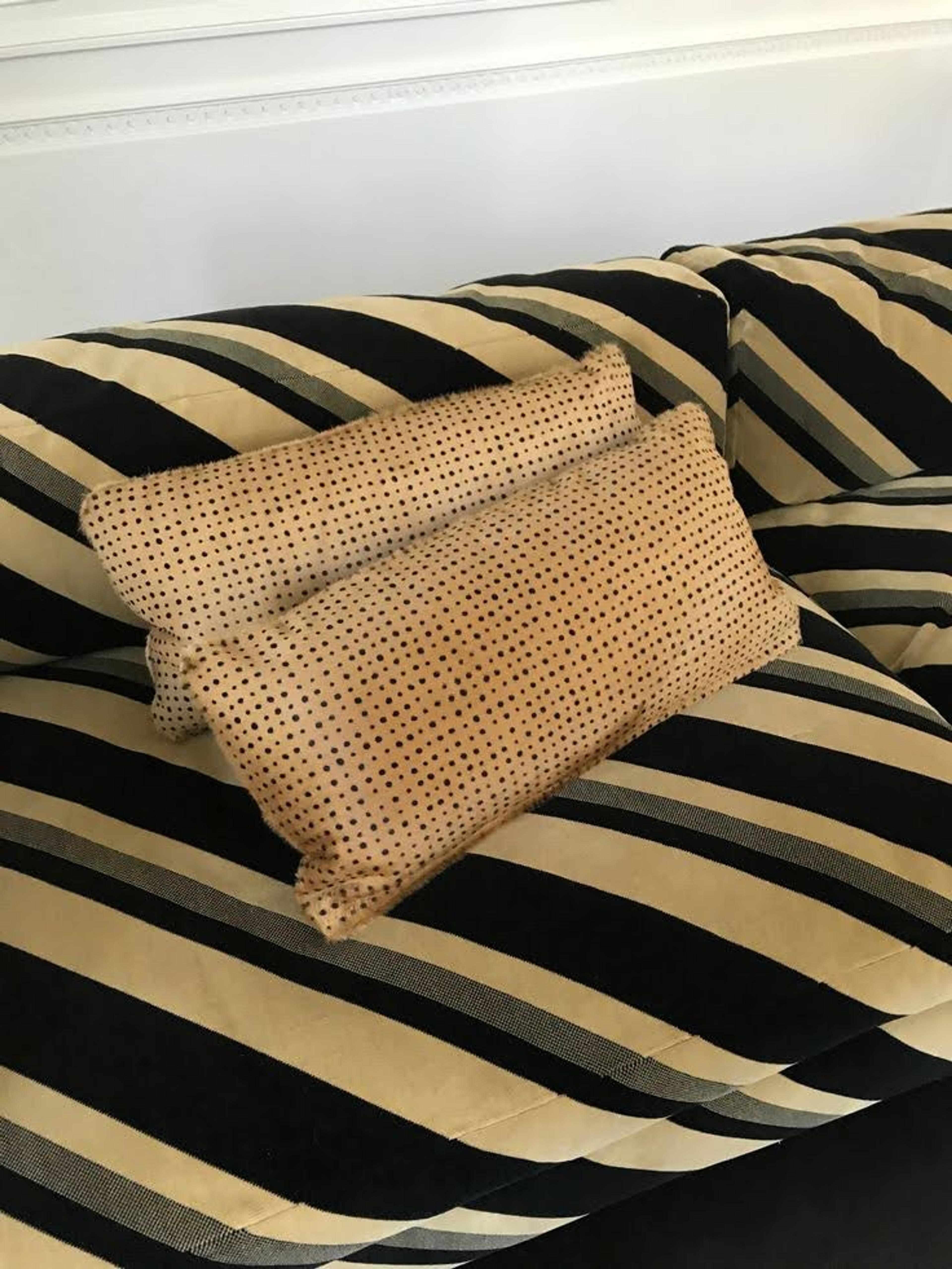 A modern curved sofa featuring a subtle diagonal striped neutral fabric