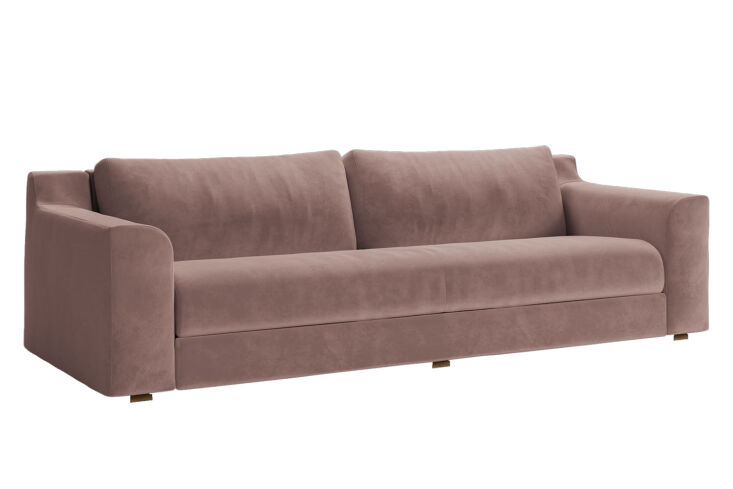 A dusty rose colored recycled velvet sofa with light wood legs.