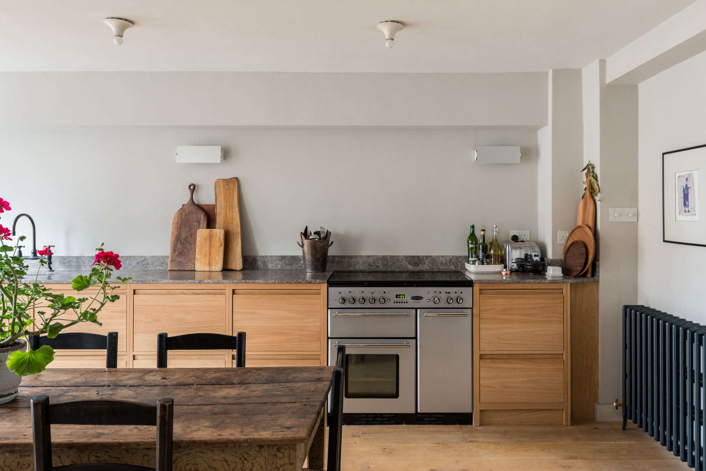 Contemporary kitchen and dining area featuring natural wood and minimalist stone surfaces.